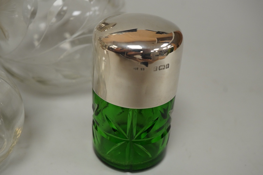 A collection of five silver mounted glass scent bottles to include one with guilloche enamel inset top, a Victorian example hallmarked for Chester 1897 and a cut glass example with mother of pearl top, London 1922, large